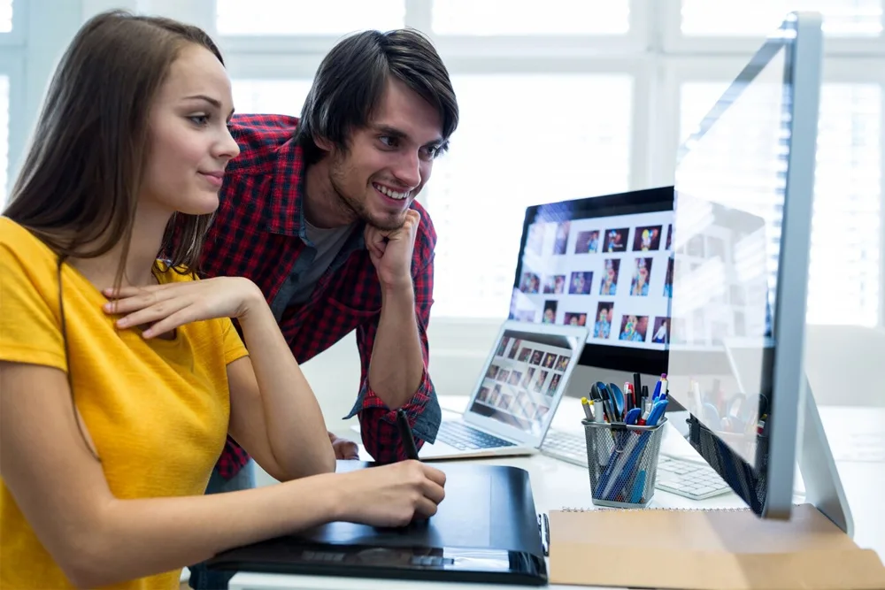 man and women looking at monitor jpg.webp