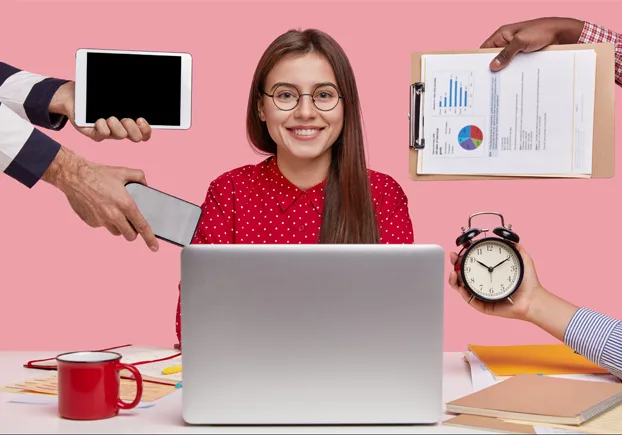 woman sitting in front of a laptop smiling at the camera.webp
